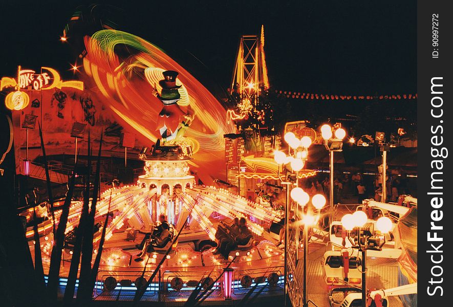 Blur of lights on ride in amusement park at night.