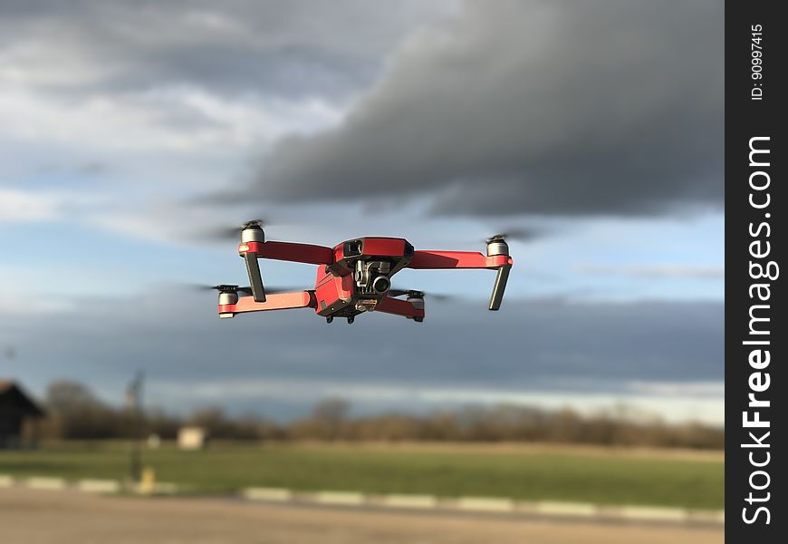 Drone flying against grey clouds in sky. Drone flying against grey clouds in sky.
