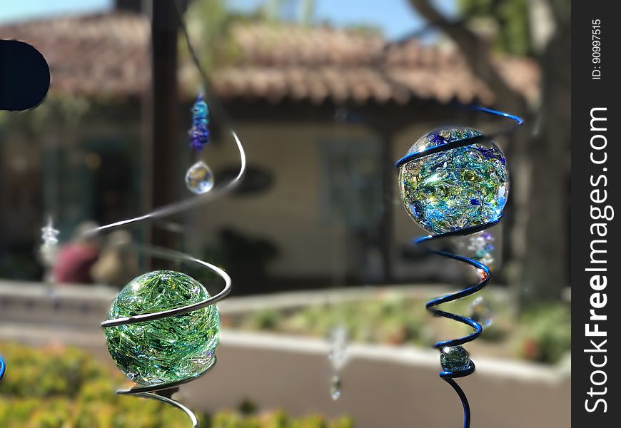 Close up of blue and green glass globes in metal lawn ornaments. Close up of blue and green glass globes in metal lawn ornaments.