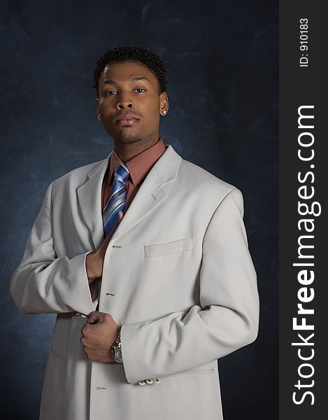 A man in a suit, posing with his hand inside his jacket. A man in a suit, posing with his hand inside his jacket