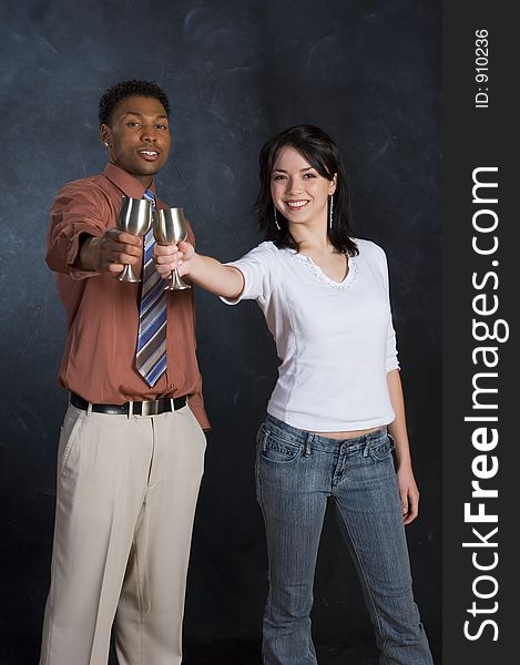 A man and woman raising their cups and smiling. A man and woman raising their cups and smiling