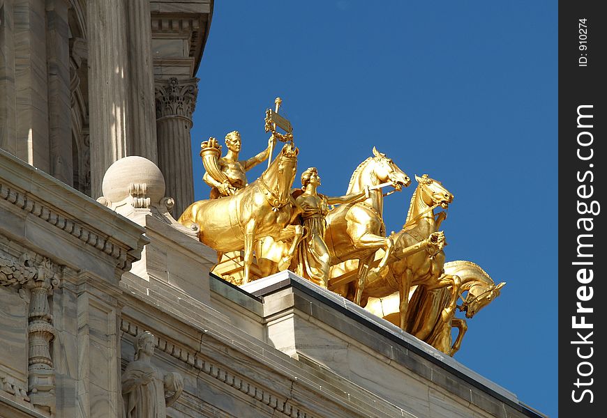 Low angle view of gold classical equestrian statues on historic building. Low angle view of gold classical equestrian statues on historic building.