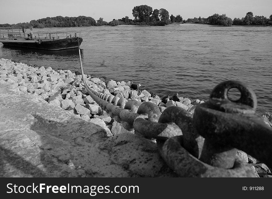 A small boat chained to the shore of the rhein river. A small boat chained to the shore of the rhein river.