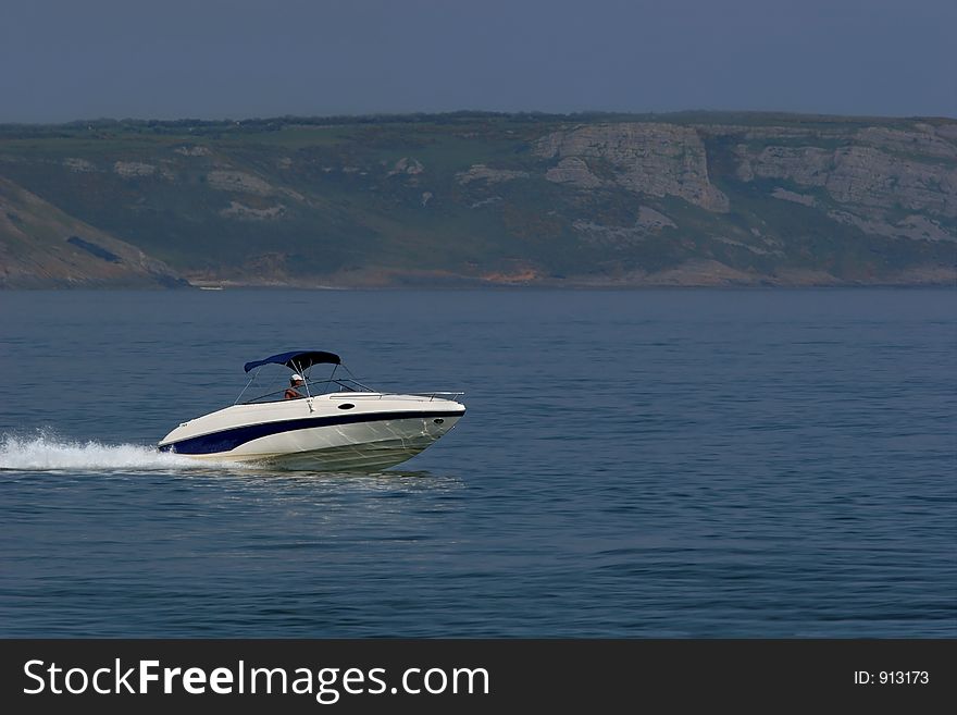Man in a blue and white speed boat on the sea. Man in a blue and white speed boat on the sea.