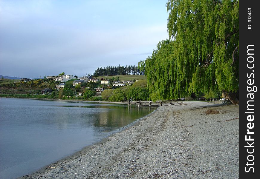 Scenic view of beach on Lake Wanaka with town in background, Otago, New Zealand.