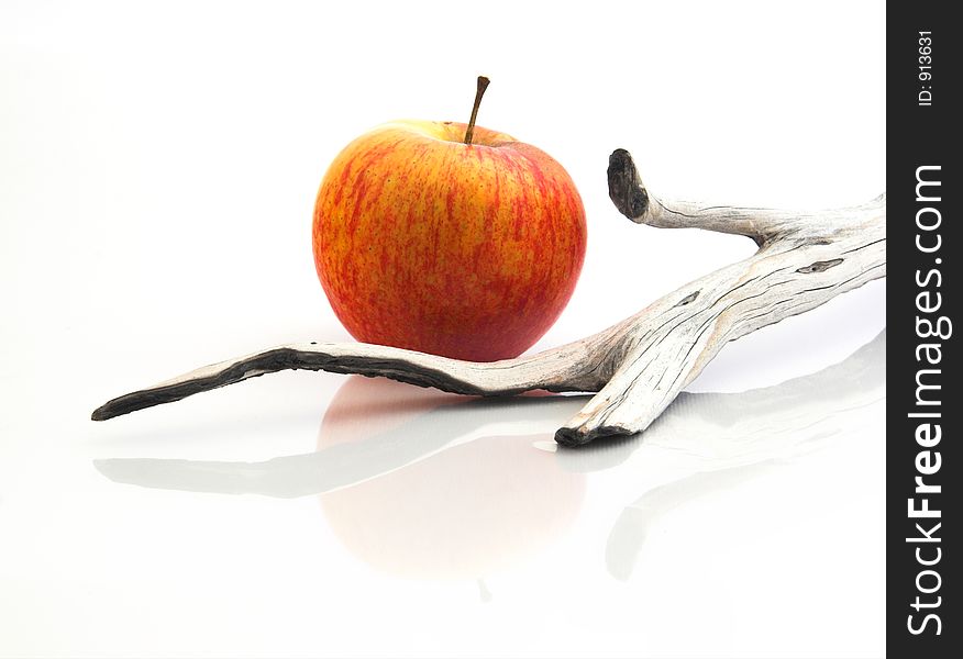 Red Apple isolated in a white background with piece of wood and reflection