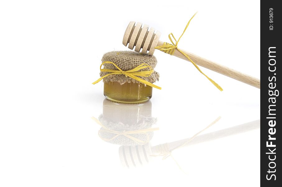 Wooden honey drizzlier and a jar of honey