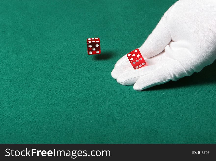 Dices being thrown in a craps game, or yatzee or any kind of dice involved game, Dices are a clear red color on a green felt table. Dices being thrown in a craps game, or yatzee or any kind of dice involved game, Dices are a clear red color on a green felt table