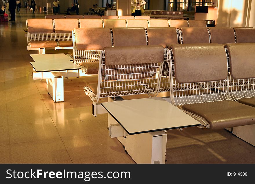 Seating in a airport lounge taken as the sun shines through in the evening light