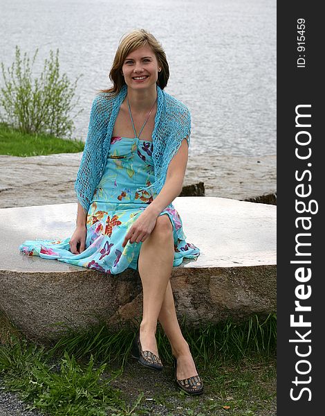 Beautiful woman sitting on a stone with sharpened surface. Beautiful woman sitting on a stone with sharpened surface