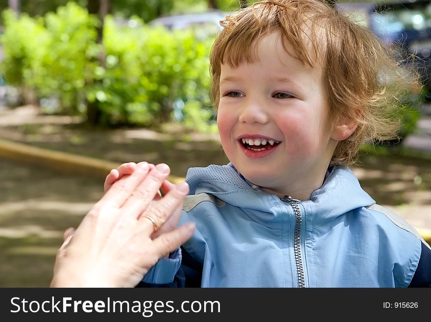 Boy holds mum`s hand