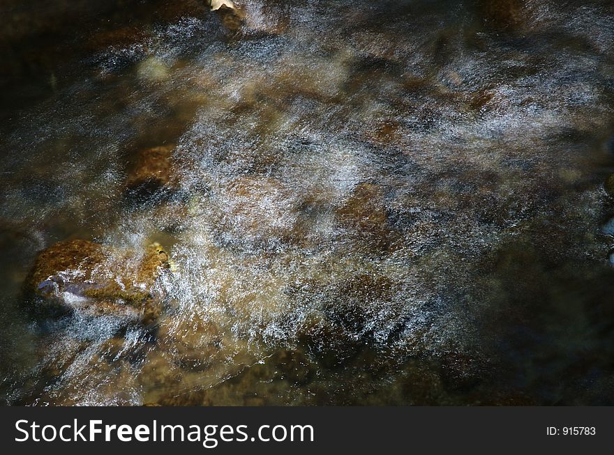 A slow shot of a stream revealing webs of fine traces of sunlight. A slow shot of a stream revealing webs of fine traces of sunlight.