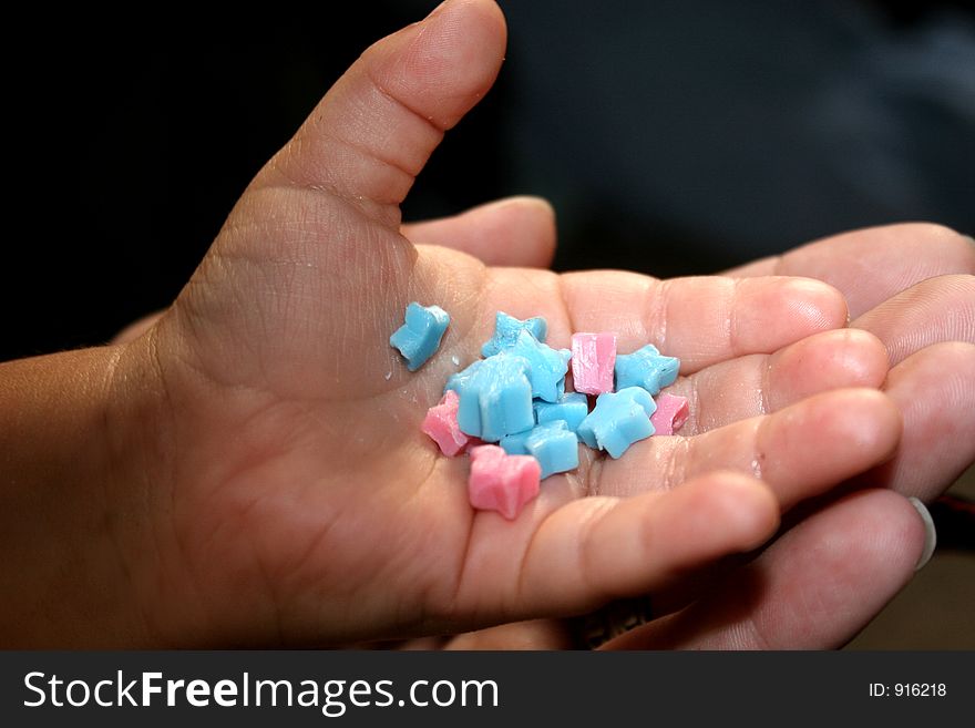 Young childs hand holding candy stars. Young childs hand holding candy stars.