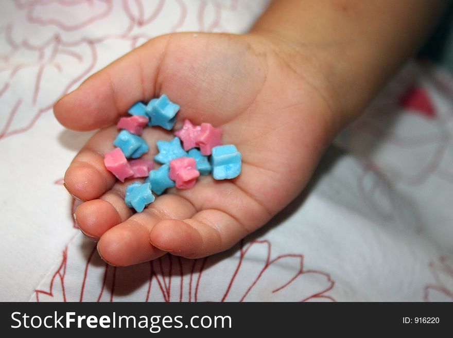 Young childs hand holding candy stars. Young childs hand holding candy stars