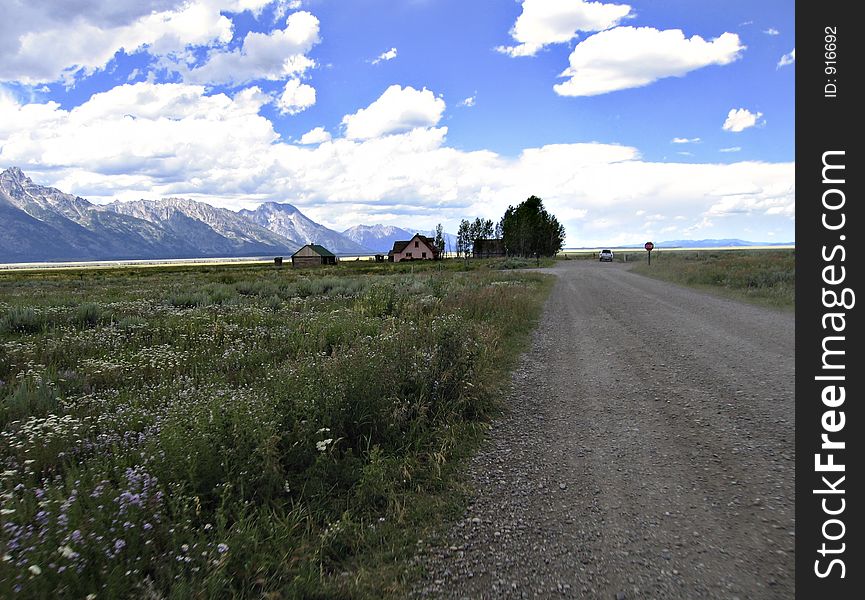 View of the Tetons in Jackson Hole, Wyoming down a country road.