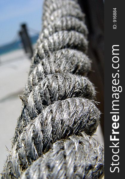 Thick rope railing on a boardwalk leading to the Gulf of Mexico. Thick rope railing on a boardwalk leading to the Gulf of Mexico
