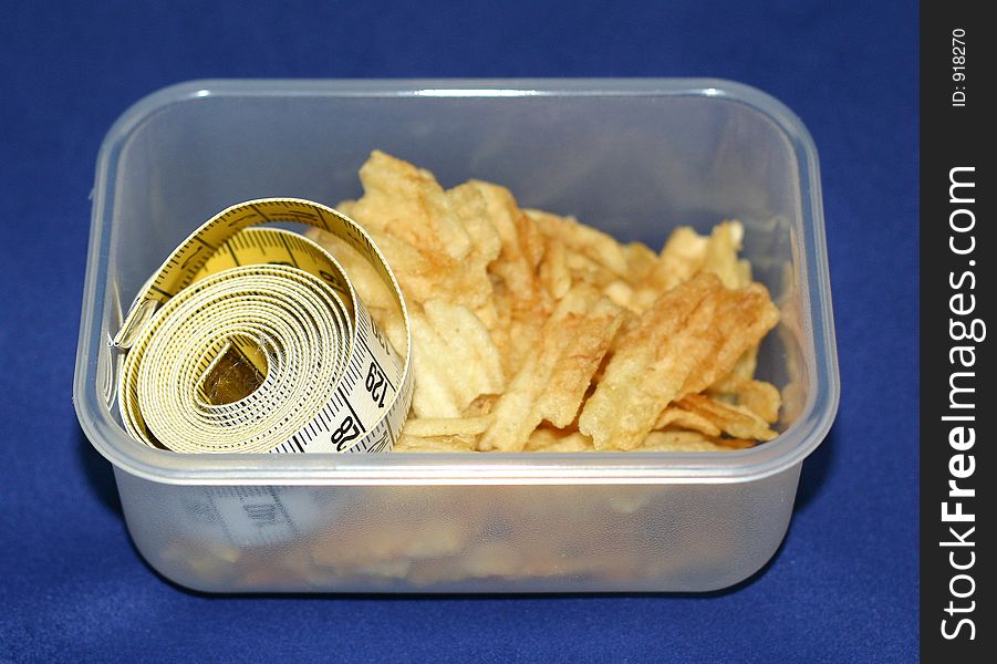A box of crisps and a measuring tape. A box of crisps and a measuring tape