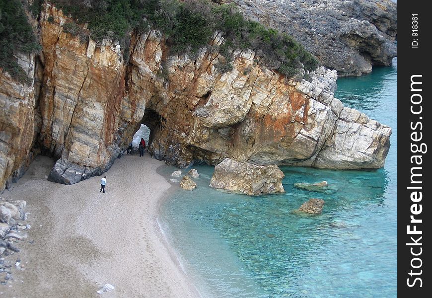 Rocks on beach, with some people walking. Rocks on beach, with some people walking