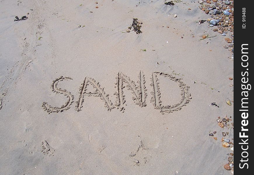 The word SAND written in sand