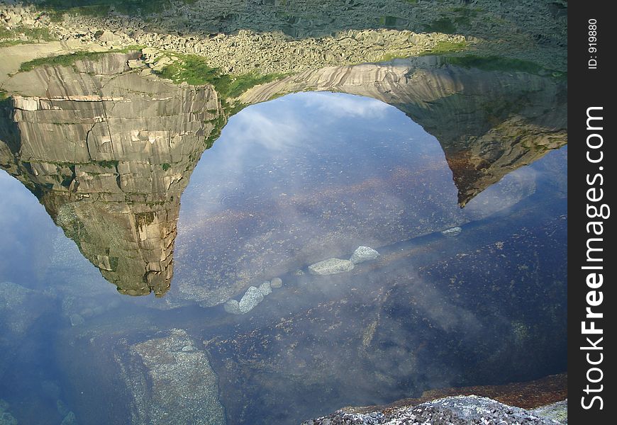 Reflection of a mountain apex with visible bottom