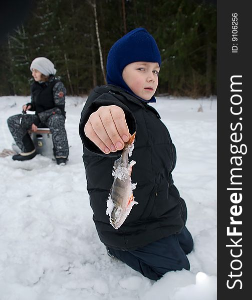 A young boy holding up the fish he has just caught. A young boy holding up the fish he has just caught.