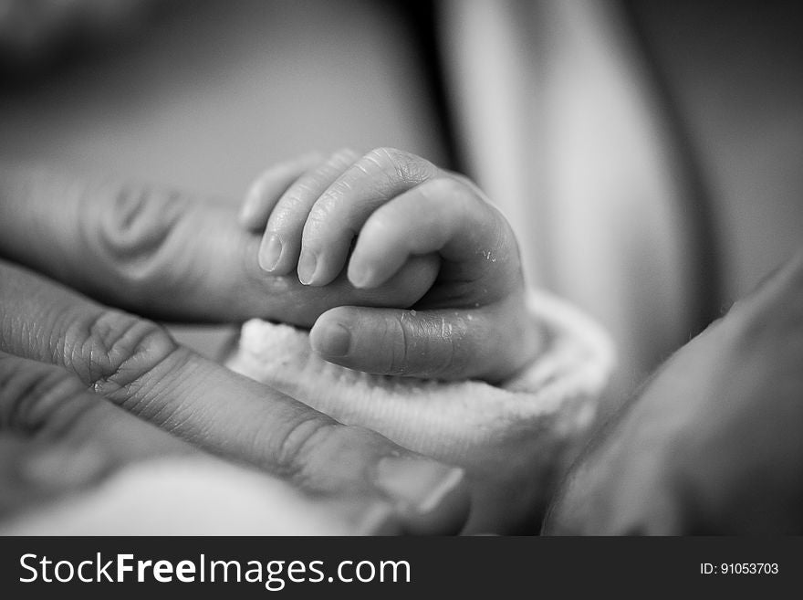 Grayscale Photography Of Baby Holding Finger