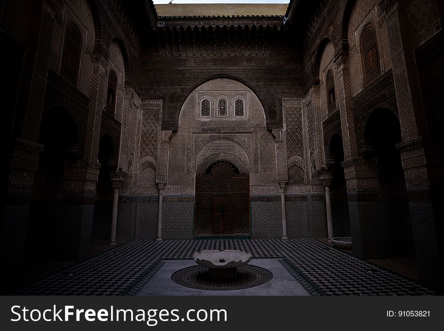 Fountain in outside courtyard of arched building in evening. Fountain in outside courtyard of arched building in evening.