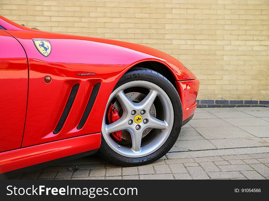 Front of red luxury Ferrari sports car outdoors.