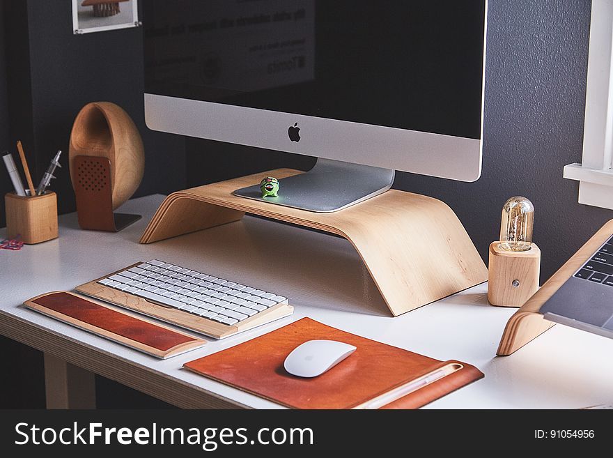 Modern desktop with Apple computer in sunny office. Modern desktop with Apple computer in sunny office.