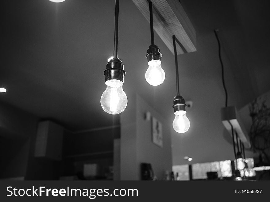 A black and white photo of hanging lightbulbs.