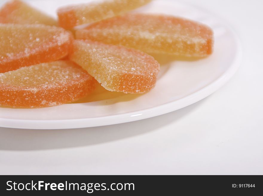 Pieces of fruit marmalade in a white plate.