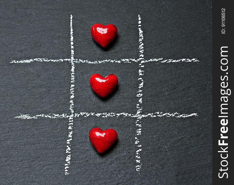 Three hearts on a tic tac toe board. Three hearts on a tic tac toe board.