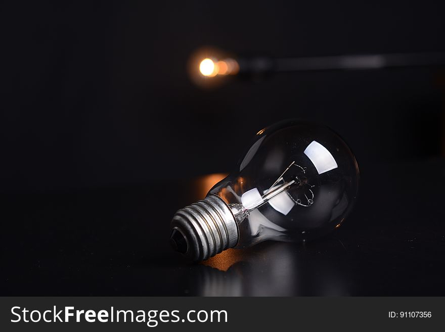 Close up of light bulb with bokeh lights in background.