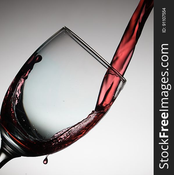 A close up of red wine pouring into a glass. A close up of red wine pouring into a glass.