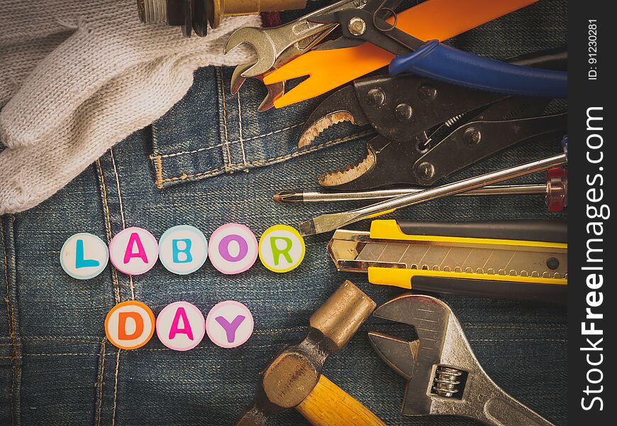 Labor day background concept - Jeans, many handy tools with labor day text on Jeans background top view