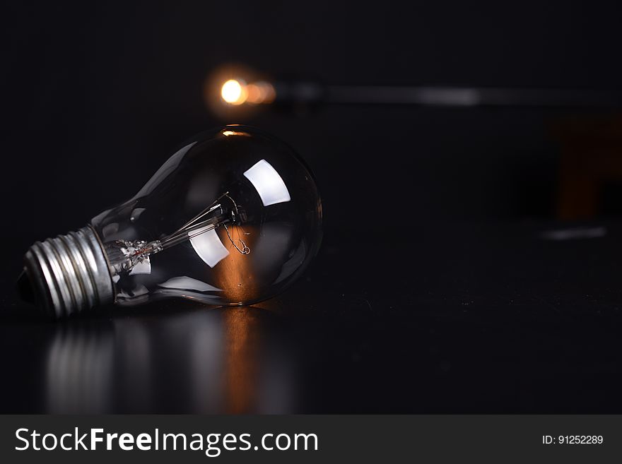 Close up of clear glass light bulb on tabletop with spotlight. Close up of clear glass light bulb on tabletop with spotlight.