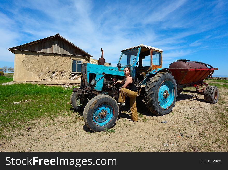 The girl repairs an old tractor