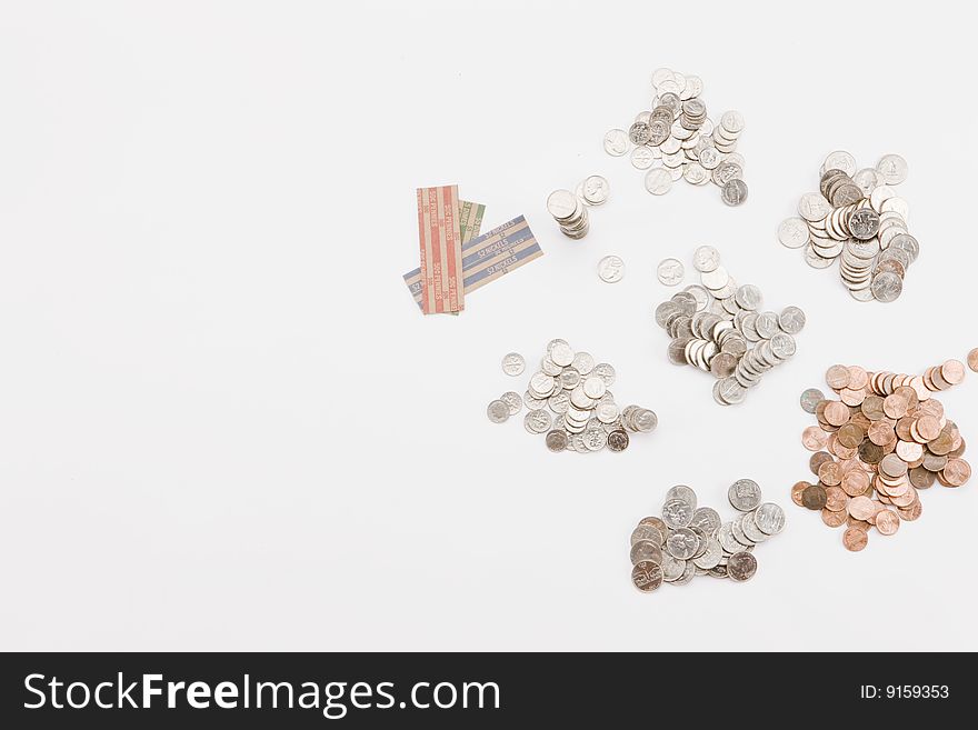 Piles of various coins and wrappers for organizing on white background. Piles of various coins and wrappers for organizing on white background