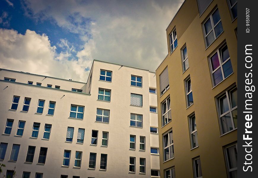 Exterior of modern office or apartment blocks against blue skies with white clouds. Exterior of modern office or apartment blocks against blue skies with white clouds.