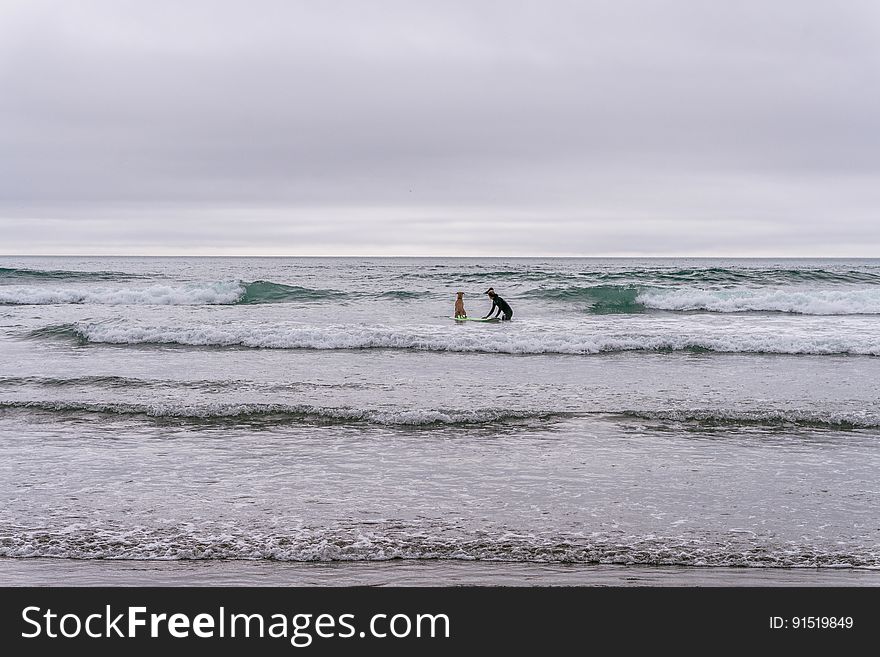 Surfers in shallow water and open sea in the background. Surfers in shallow water and open sea in the background.