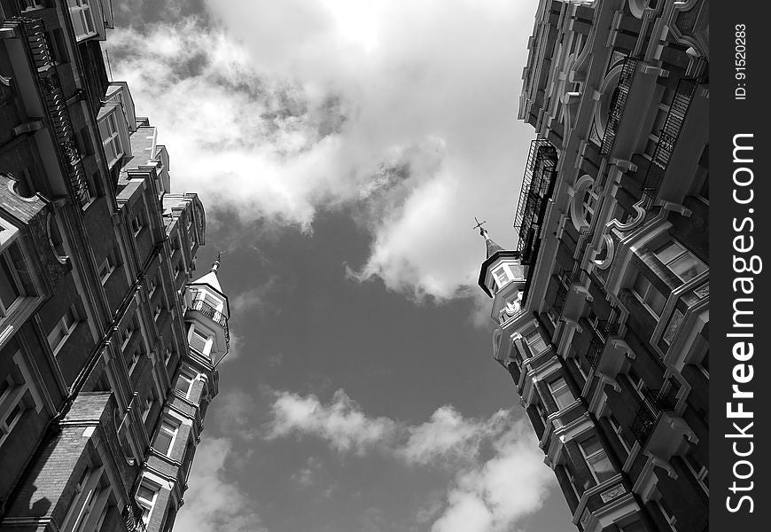 A black and white photo of residential buildings from a low angle. A black and white photo of residential buildings from a low angle.