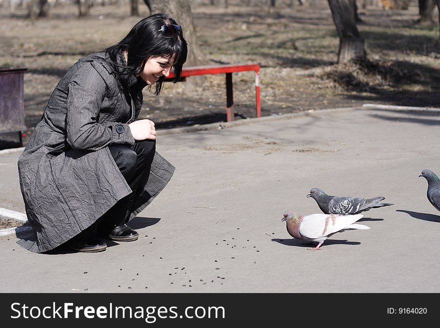 Nice girl feeding birds in park