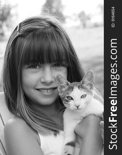 Cute happy girl holding small cat in the countryside. Cute happy girl holding small cat in the countryside