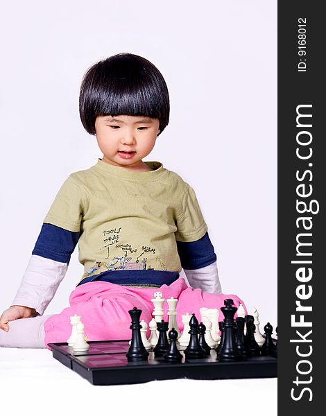 A picture of a little chinese girl playing chess alone