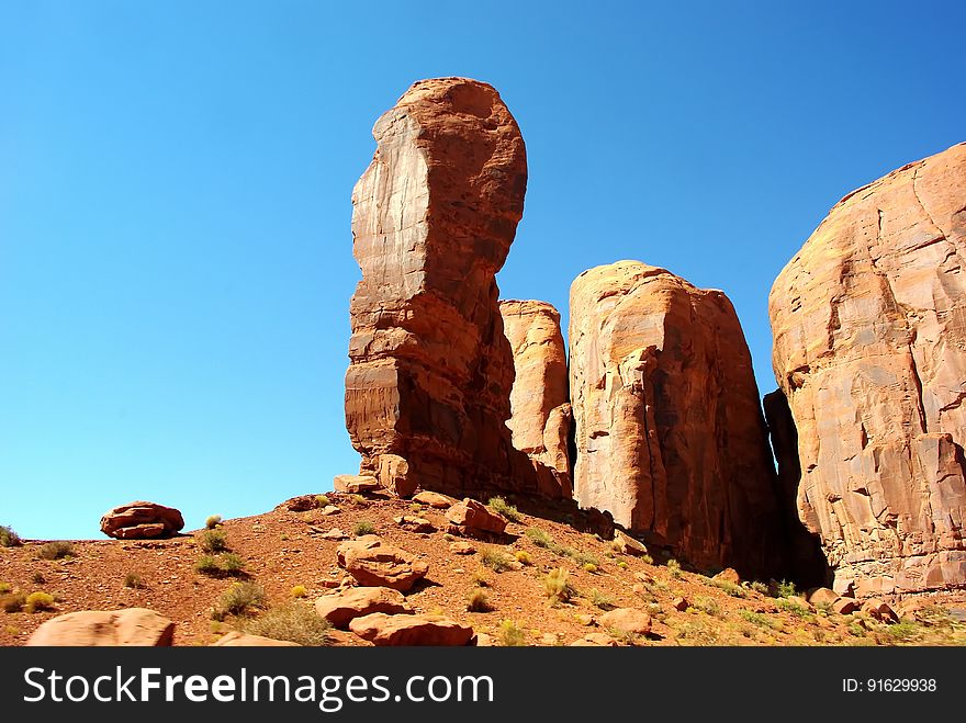 Sandstone rock formation in desert against blue skies on sunny day.