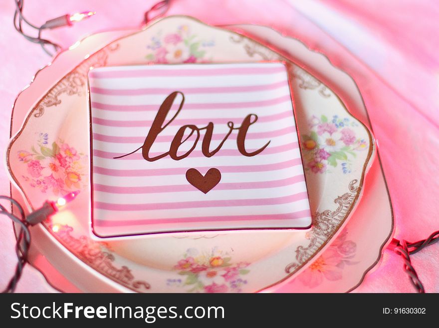 A pink striped plate with the text love and a heart symbol. A pink striped plate with the text love and a heart symbol.