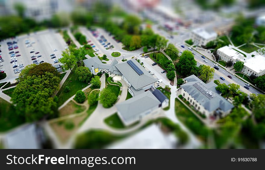 A model of a college building with a parking lot and a park. A model of a college building with a parking lot and a park.