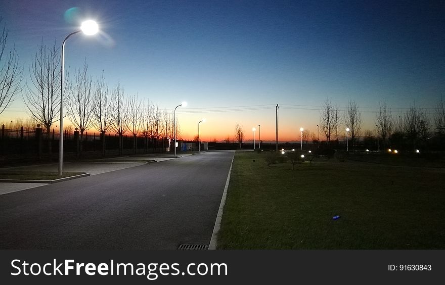 A street with lampposts at sunset. A street with lampposts at sunset.