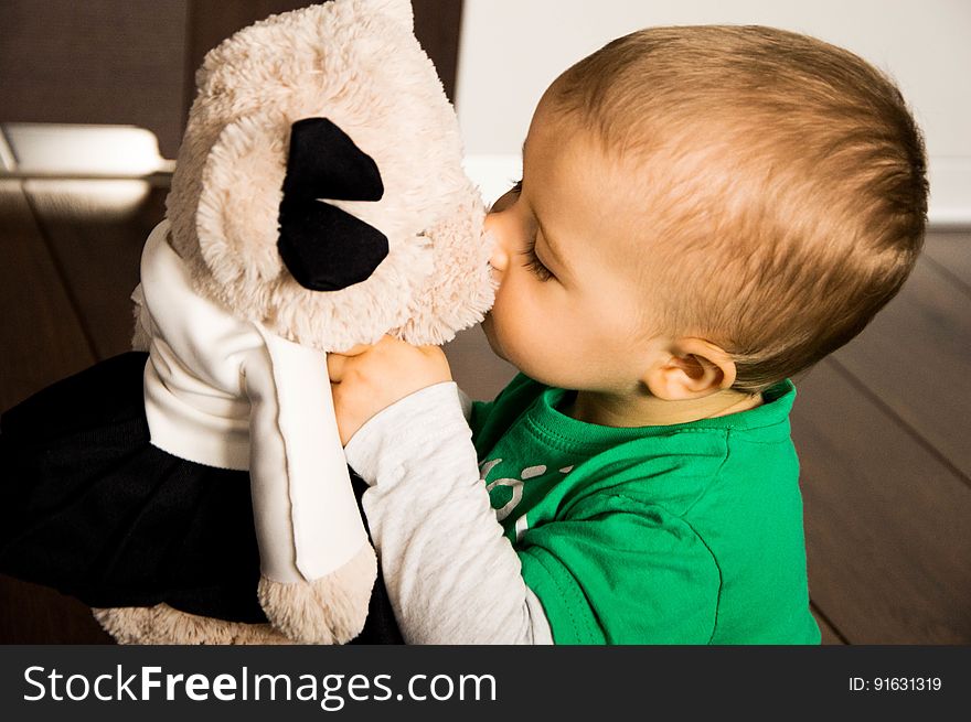 A close up of a toddler boy kissing a teddy bear. A close up of a toddler boy kissing a teddy bear.