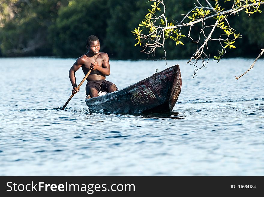 Man In Black Shorts Riding Rowboat During Daytime